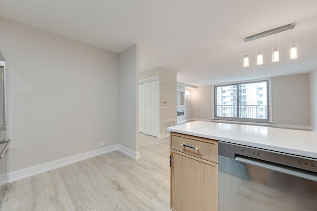 kitchen featuring light countertops, dishwasher, light brown cabinets, baseboards, and light wood-style floors