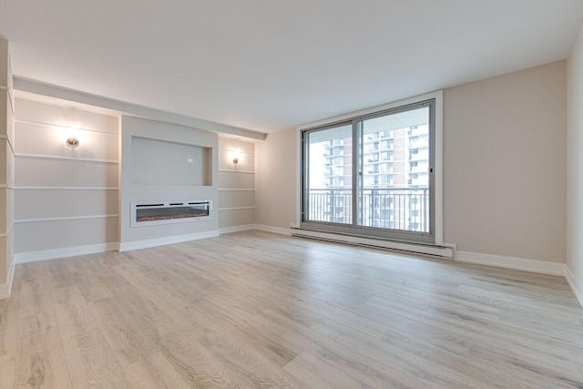 unfurnished living room featuring baseboards, baseboard heating, wood finished floors, and a glass covered fireplace