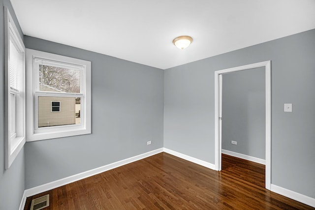 empty room featuring visible vents, baseboards, and wood finished floors