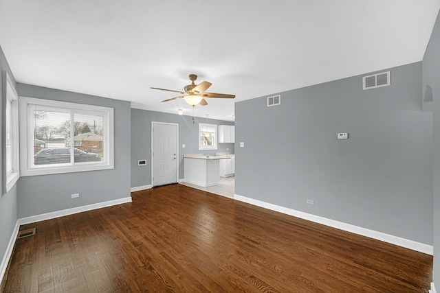 unfurnished living room featuring visible vents, baseboards, wood finished floors, and ceiling fan