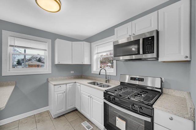 kitchen featuring a sink, visible vents, appliances with stainless steel finishes, and white cabinetry