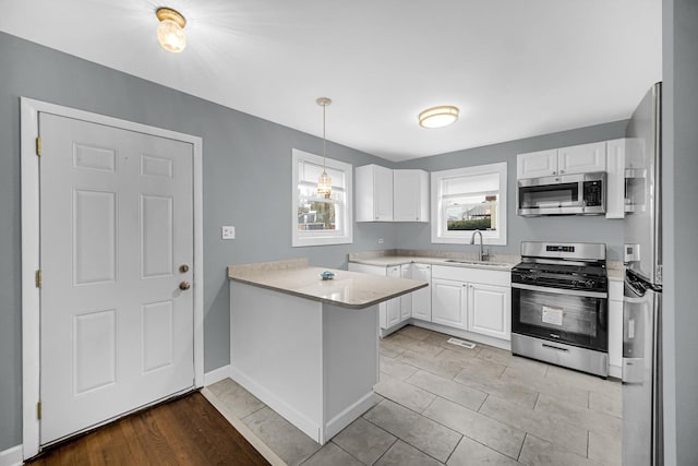 kitchen featuring appliances with stainless steel finishes, light countertops, and white cabinets