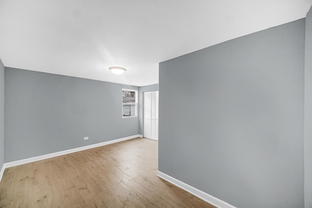 unfurnished room with wood finished floors and baseboards