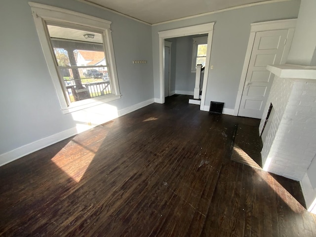 405 Chandler St, Danville, IL 61832 - unfurnished living room with plenty of natural light, dark wood-type flooring, and baseboards