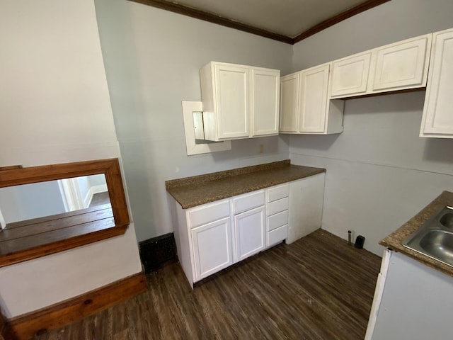 405 Chandler St, Danville, IL 61832 - kitchen featuring crown molding, dark countertops, white cabinetry, a sink, and dark wood-style floors