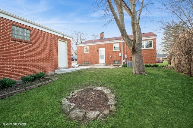 270 W 10th St, Chicago Heights, IL 60411 - rear view of house with a lawn, central AC unit, entry steps, brick siding, and a chimney