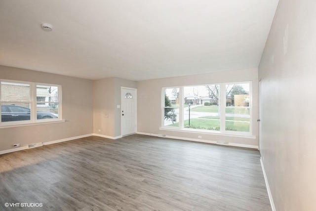 270 W 10th St, Chicago Heights, IL 60411 - unfurnished living room with a wealth of natural light, baseboards, and wood finished floors