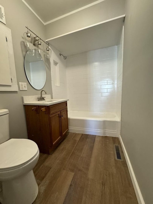 full bathroom featuring washtub / shower combination, vanity, toilet, visible vents, and wood finished floors