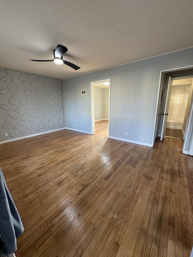 unfurnished room featuring visible vents, baseboards, ceiling fan, hardwood / wood-style flooring, and a textured ceiling