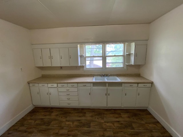716 Robinson St, Danville, IL 61832 - kitchen featuring light countertops, a sink, baseboards, white cabinets, and dark wood-type flooring