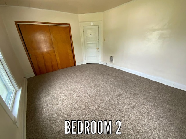 716 Robinson St, Danville, IL 61832 - unfurnished bedroom featuring baseboards, carpet, a closet, and visible vents