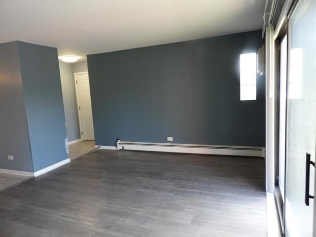 13715 S Stewart Ave Unit 2E, Riverdale, IL 60827 - empty room featuring wood finished floors, a baseboard radiator, and baseboards
