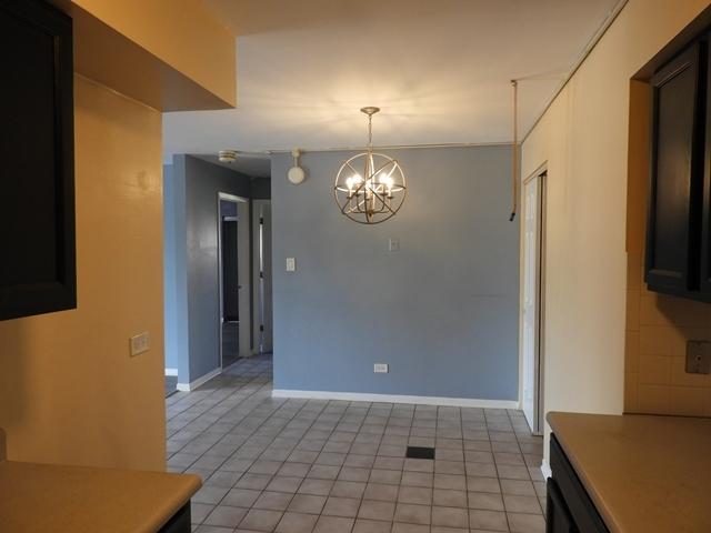 13715 S Stewart Ave Unit 2E, Riverdale, IL 60827 - unfurnished dining area with a chandelier, baseboards, and light tile patterned flooring