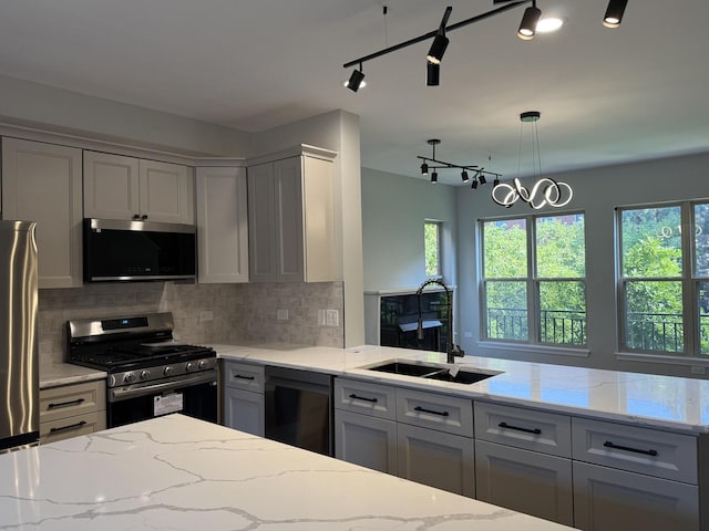 1333 N Burling St Unit B, Chicago, IL 60610 - kitchen featuring stainless steel appliances, backsplash, light stone countertops, and a peninsula