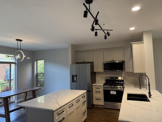 1333 N Burling St Unit B, Chicago, IL 60610 - kitchen with appliances with stainless steel finishes, decorative backsplash, light stone countertops, decorative light fixtures, and dark wood finished floors