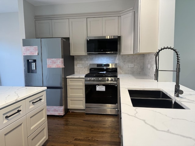 1333 N Burling St Unit B, Chicago, IL 60610 - kitchen with stainless steel appliances, decorative backsplash, dark wood-style floors, and light stone counters