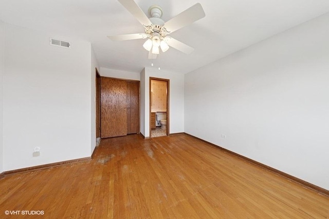 unfurnished bedroom with visible vents, connected bathroom, light wood-style floors, and baseboards