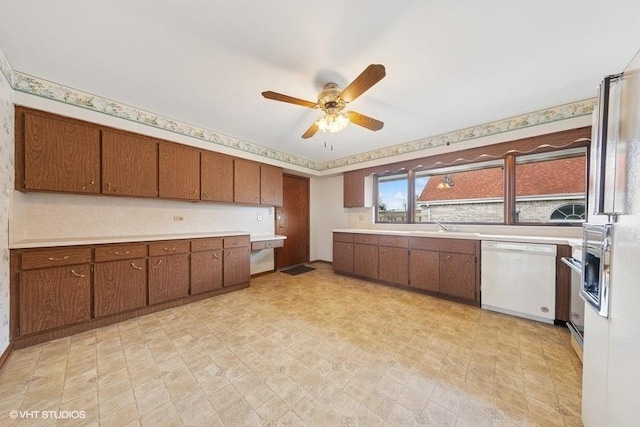 kitchen with light countertops, brown cabinetry, and dishwasher