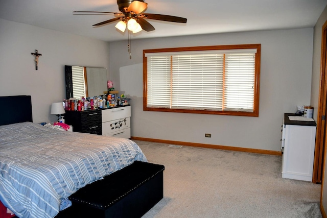 bedroom with baseboards, multiple windows, and light colored carpet