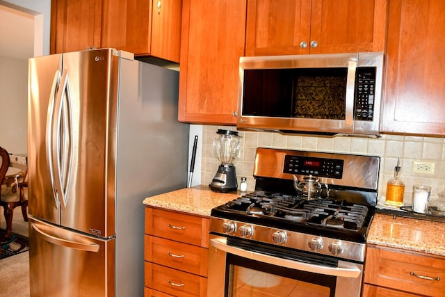 kitchen featuring backsplash, brown cabinets, and stainless steel appliances