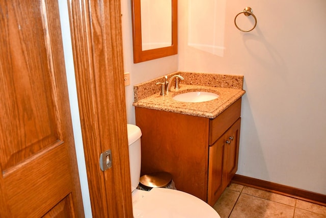 bathroom with baseboards, toilet, vanity, and tile patterned floors