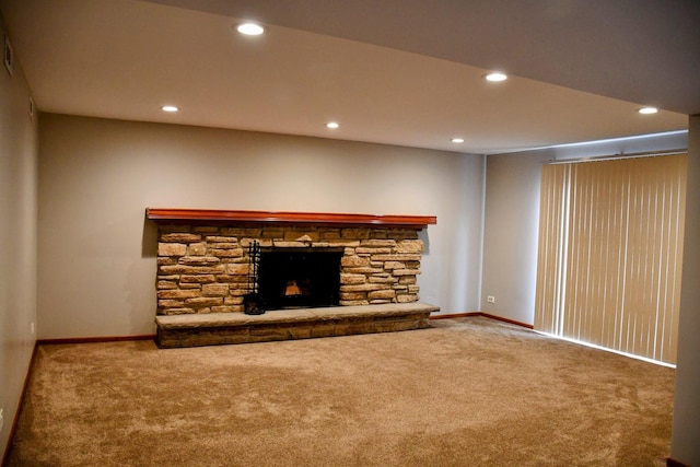 unfurnished living room with baseboards, a stone fireplace, carpet flooring, and recessed lighting