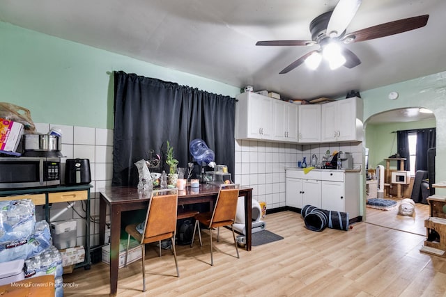 3041 S Drake Ave, Chicago, IL 60623 - kitchen featuring white cabinetry, light wood-type flooring, stainless steel microwave, arched walkways, and ceiling fan