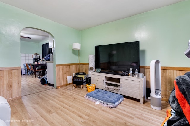 3041 S Drake Ave, Chicago, IL 60623 - living room featuring wainscoting, wood finished floors, arched walkways, and wood walls