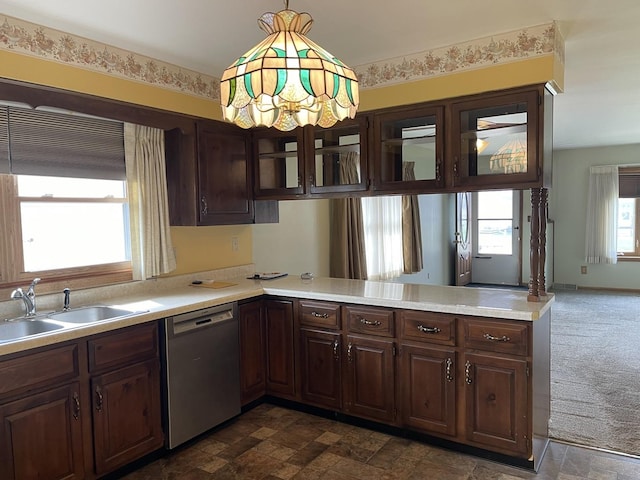 kitchen with light countertops, a peninsula, dark carpet, a sink, and stainless steel dishwasher