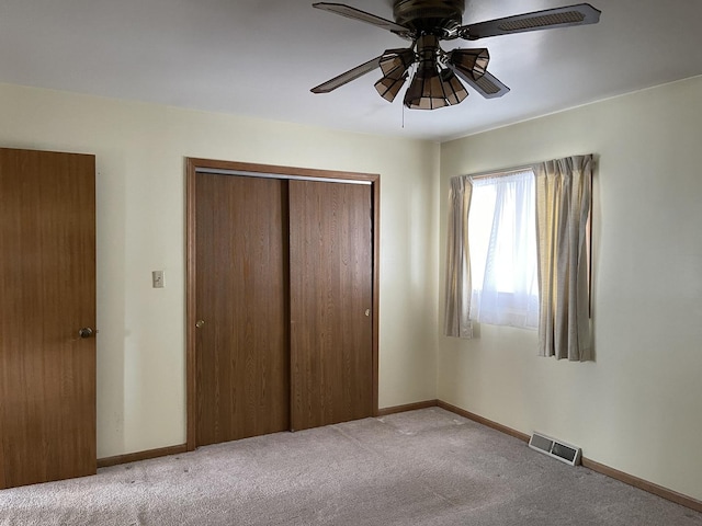 unfurnished bedroom with a closet, visible vents, baseboards, ceiling fan, and carpet floors
