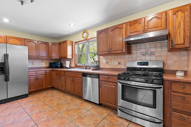 3315 E Bemes Rd, Crete, IL 60417 - kitchen featuring appliances with stainless steel finishes, under cabinet range hood, light tile patterned floors, brown cabinets, and recessed lighting