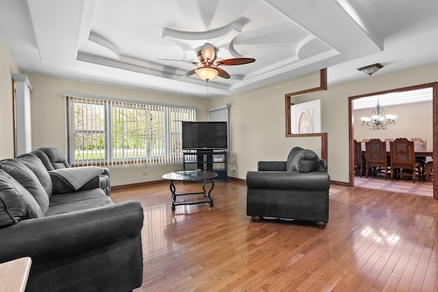 3315 E Bemes Rd, Crete, IL 60417 - living area featuring a tray ceiling, a chandelier, light wood-style flooring, a ceiling fan, and baseboards