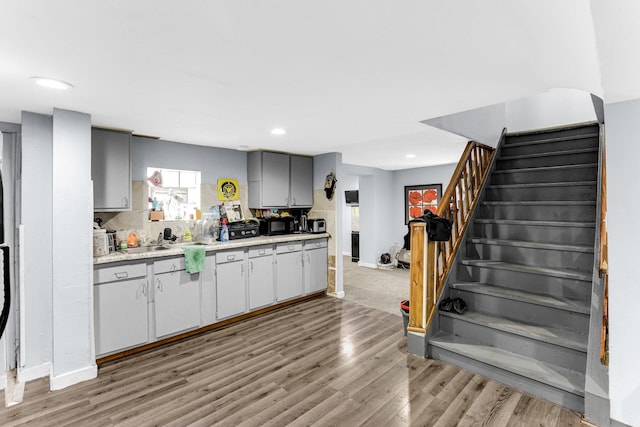 kitchen with light countertops, recessed lighting, light wood-type flooring, gray cabinets, and baseboards