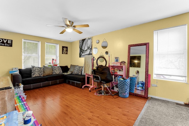 living area with a ceiling fan, baseboards, light wood finished floors, and visible vents
