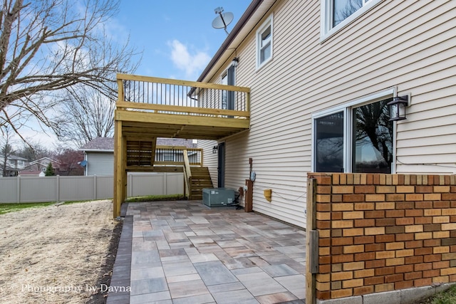 view of patio with a wooden deck, fence, and stairway