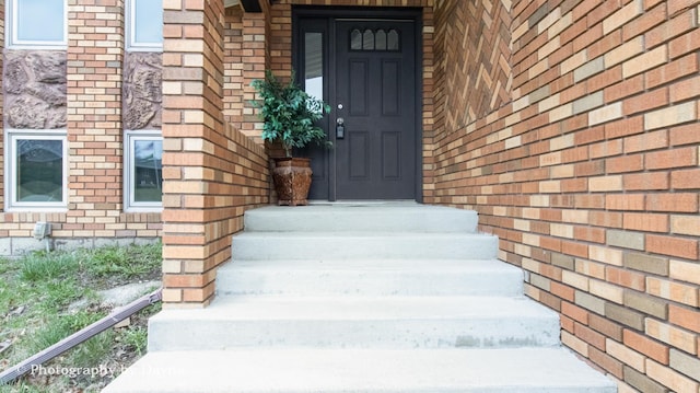 property entrance featuring brick siding