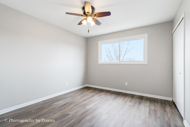 unfurnished bedroom with a ceiling fan, baseboards, a closet, and wood finished floors