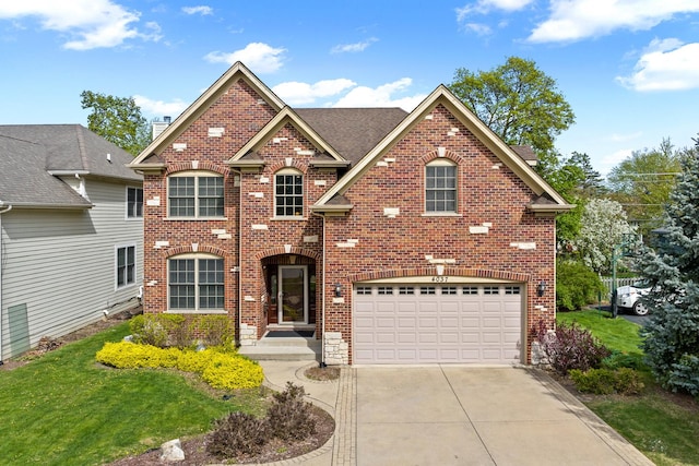 view of front of property with brick siding, an attached garage, and driveway
