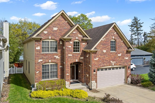 traditional-style house featuring brick siding, roof with shingles, fence, and driveway
