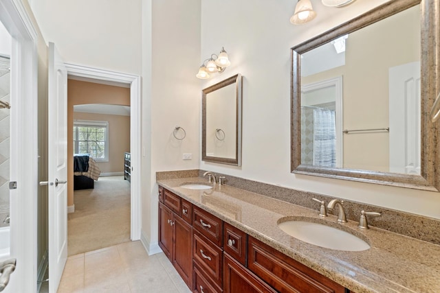 ensuite bathroom with double vanity, a sink, tile patterned floors, and curtained shower