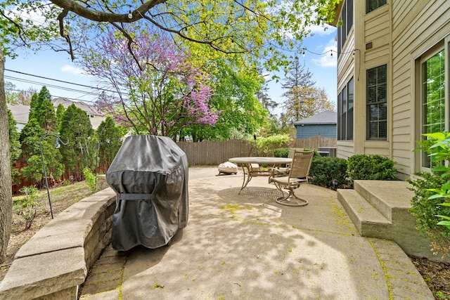 view of patio with area for grilling, fence, and outdoor dining area