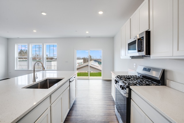 kitchen featuring a sink, appliances with stainless steel finishes, dark wood-style floors, white cabinets, and recessed lighting
