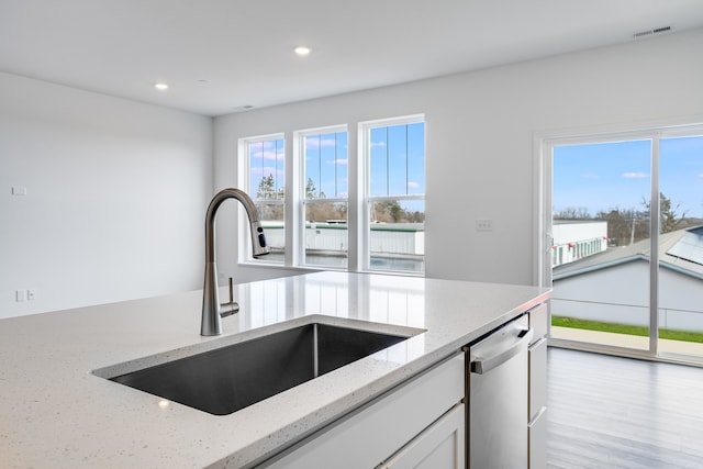 kitchen with recessed lighting, a sink, visible vents, white cabinets, and light stone countertops