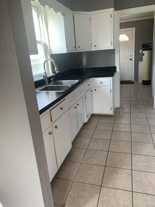 26W441 Geneva Rd, Wheaton, IL 60187 - kitchen with light tile patterned floors, white cabinetry, a sink, dark countertops, and water heater