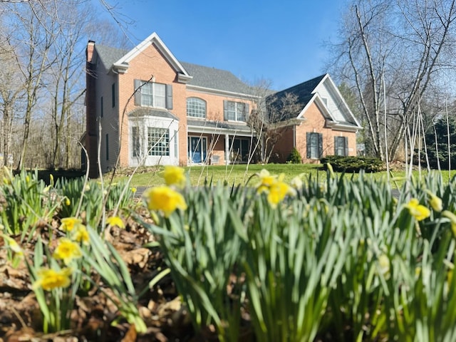 traditional-style home with brick siding and a chimney