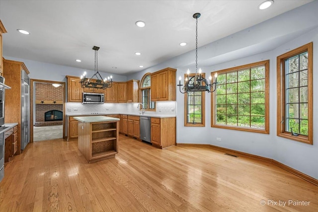 kitchen featuring visible vents, open shelves, stainless steel appliances, and a notable chandelier