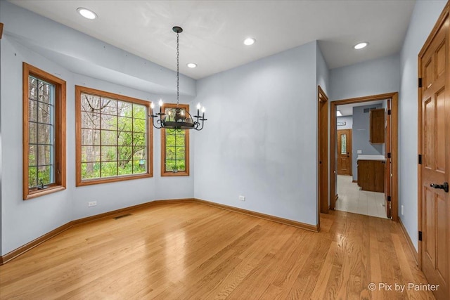unfurnished dining area featuring an inviting chandelier, visible vents, baseboards, recessed lighting, and light wood-style flooring