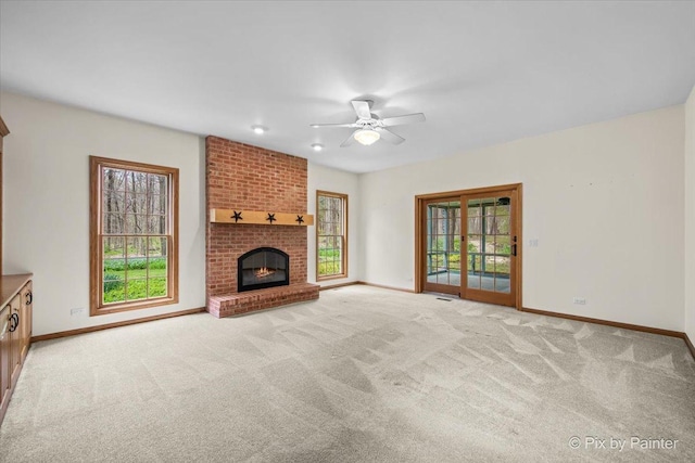 unfurnished living room featuring baseboards, ceiling fan, and a wealth of natural light