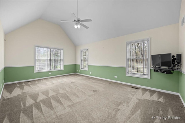 interior space with a ceiling fan, baseboards, vaulted ceiling, and carpet