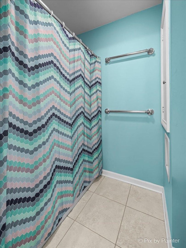 full bathroom with tile patterned flooring, baseboards, and a shower with curtain